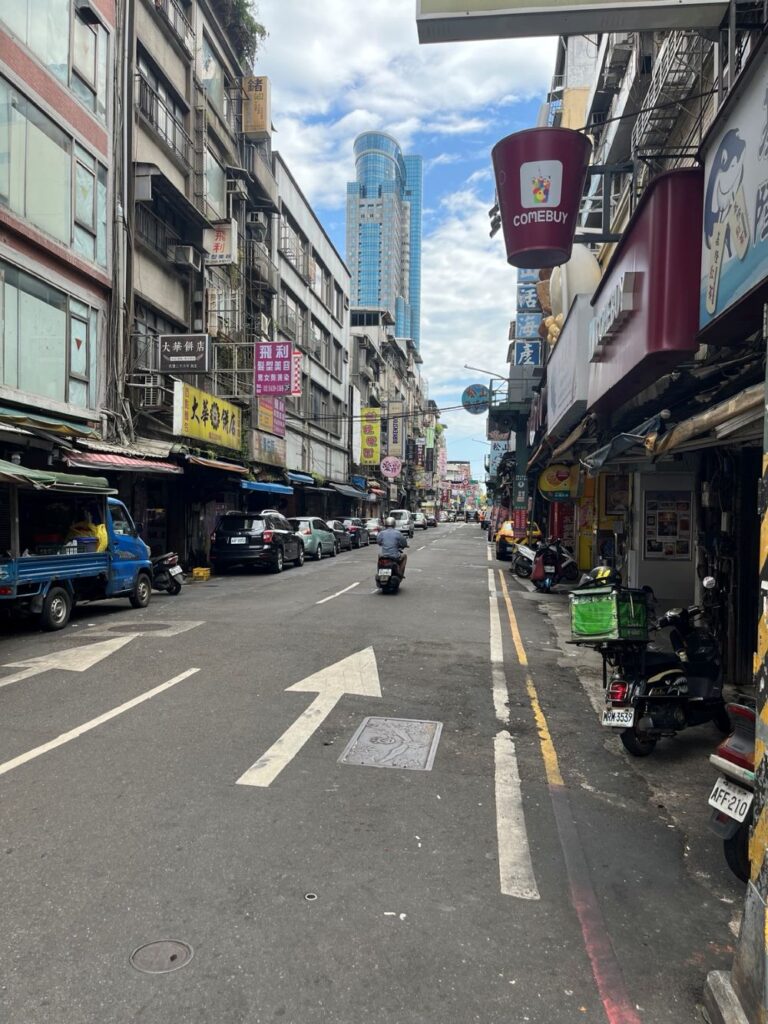 台湾・基隆市街地の風景。古い街並みと高層ビルが並ぶ道路。